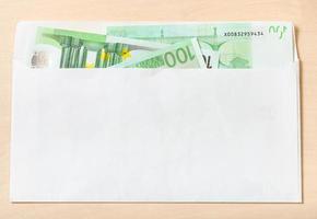 De nombreux billets de cent euros dans une enveloppe sur la table photo