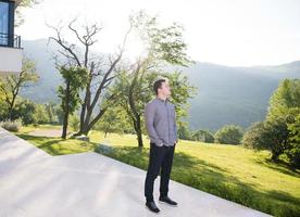 homme devant sa villa de luxe photo