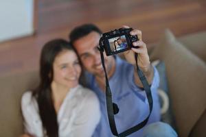 couple jouant avec un appareil photo numérique à la maison