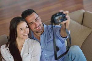 couple jouant avec un appareil photo numérique à la maison