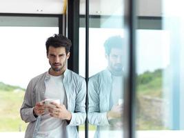 un jeune homme détendu boit le premier café du matin photo