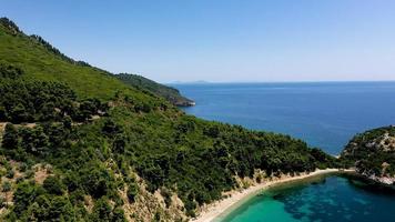 vue aérienne par drone sur une côte rocheuse, des eaux cristallines de la mer Égée, des plages touristiques et beaucoup de verdure sur l'île de skopelos, en grèce. une vue typique de nombreuses îles grecques similaires.