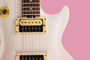 partie avant du corps d'une guitare électrique blanche sur fond rose photo