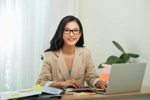 mère de femme d'affaires asiatique travaillant à la maison avec un ordinateur portable. concept de travail à domicile. photo