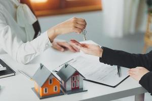 l'agent immobilier ou l'agence donnant la clé de la maison au client après la signature du contrat d'accord. notion de propriété. photo