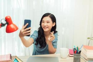 heureuse fille asiatique souriante sur un téléphone d'appel vidéo, prenant un selfie sur un smartphone, photo