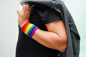 femme asiatique avec drapeau arc-en-ciel, droits des symboles lgbt et égalité des sexes, mois de la fierté lgbt en juin. photo