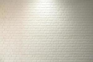 mur de briques peint en blanc dans le bâtiment. il y a un plafonnier. photo