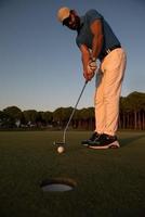 golfeur frappant le coup au terrain de golf photo