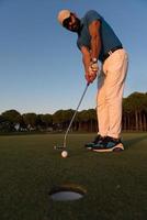 golfeur frappant le coup au terrain de golf photo