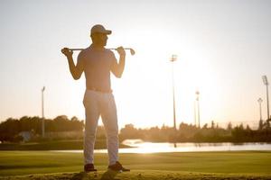 portrait de golfeur au terrain de golf au coucher du soleil photo