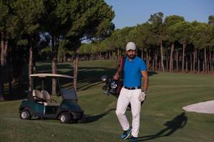 golfeur marchant et portant un sac de golf photo