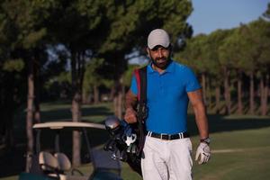 golfeur marchant et portant un sac de golf photo