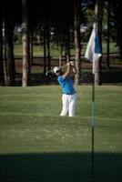 golfeur professionnel frappant un coup de bunker de sable photo
