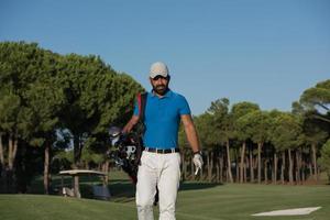 golfeur marchant et portant un sac de golf photo