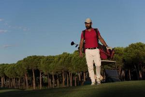 golfeur marchant et portant un sac de golf photo