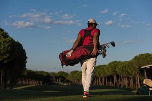 golfeur marchant et portant un sac de golf photo