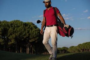 golfeur marchant et portant un sac de golf photo