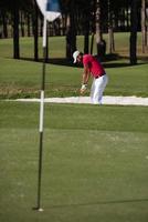 golfeur frappant un coup de bunker de sable photo