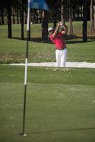 golfeur frappant un coup de bunker de sable photo