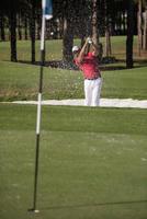 golfeur frappant un coup de bunker de sable photo