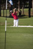 golfeur frappant un coup de bunker de sable photo