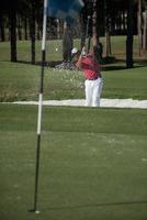 golfeur frappant un coup de bunker de sable photo