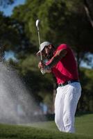 golfeur frappant un coup de bunker de sable photo