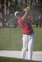 golfeur frappant un coup de bunker de sable photo