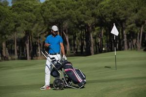 joueur de golf marchant avec un sac à roulettes photo