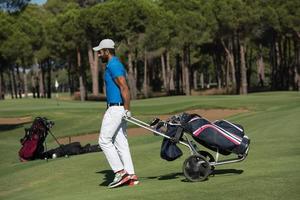 joueur de golf marchant avec un sac à roulettes photo