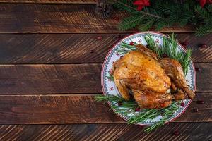 poulet entier ou dinde cuit au four pour noël. table du nouvel an avec décoration, poulet rôti maison, vin et salade. vue de dessus photo