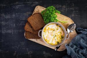 soupe de saumon crémeuse avec pomme de terre, carotte, poireau et pain. soupe lohikeitto, cuisine finlandaise. vue de dessus photo