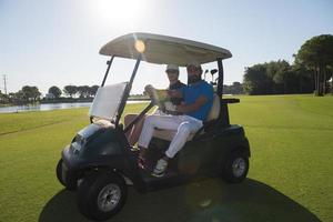 joueurs de golf conduisant une voiturette au cours photo