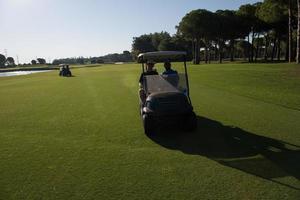 joueurs de golf conduisant une voiturette au cours photo