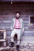 portrait de jeune hipster devant une maison en bois photo