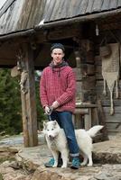 jeune hipster avec chien devant une maison en bois photo