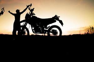 silhouettes masculines et vélos de motocross de tourisme. parc pour se détendre à la montagne le soir. concept de voyage d'aventure et de loisirs photo