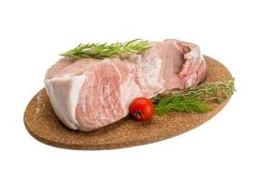 Viande de porc crue sur plaque de bois et fond blanc photo