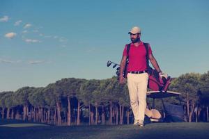 golfeur marchant et portant un sac de golf photo