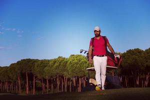 golfeur marchant et portant un sac de golf photo