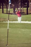 golfeur frappant un coup de bunker de sable photo