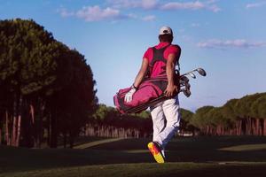 golfeur marchant et portant un sac de golf photo