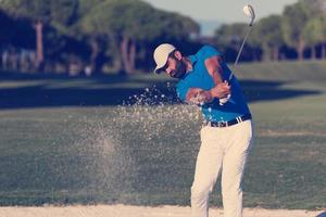 golfeur professionnel frappant un coup de bunker de sable photo