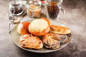 tartes à la pâte à levure sucrée avec différentes garnitures sur plateau et verre de thé photo