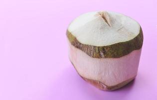 fruit tropical de noix de coco sur fond rose - été frais de jus de noix de coco pour boire de l'eau, gros plan sur une jeune noix de coco photo