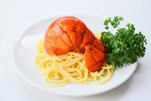 queue de homard bouillie spaghettis cuits fruits de mer nourriture de homard sur une plaque blanche
