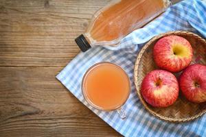 vinaigre de cidre de pomme remèdes naturels et remèdes pour les problèmes de santé courants, vinaigre de cidre de pomme biologique brut et non filtré en verre avec pomme sur la table en bois photo