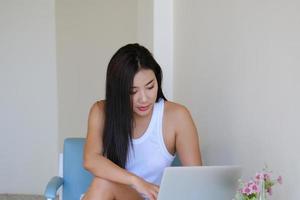 nouvelle normalité, une femme d'affaires utilisant un ordinateur pour travailler pour une entreprise via Internet sur votre bureau à la maison. photo