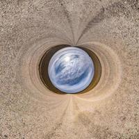 inversion de la petite planète bleue transformation du panorama sphérique à 360 degrés. vue aérienne abstraite sphérique sur route avec de beaux nuages impressionnants. courbure de l'espace. photo